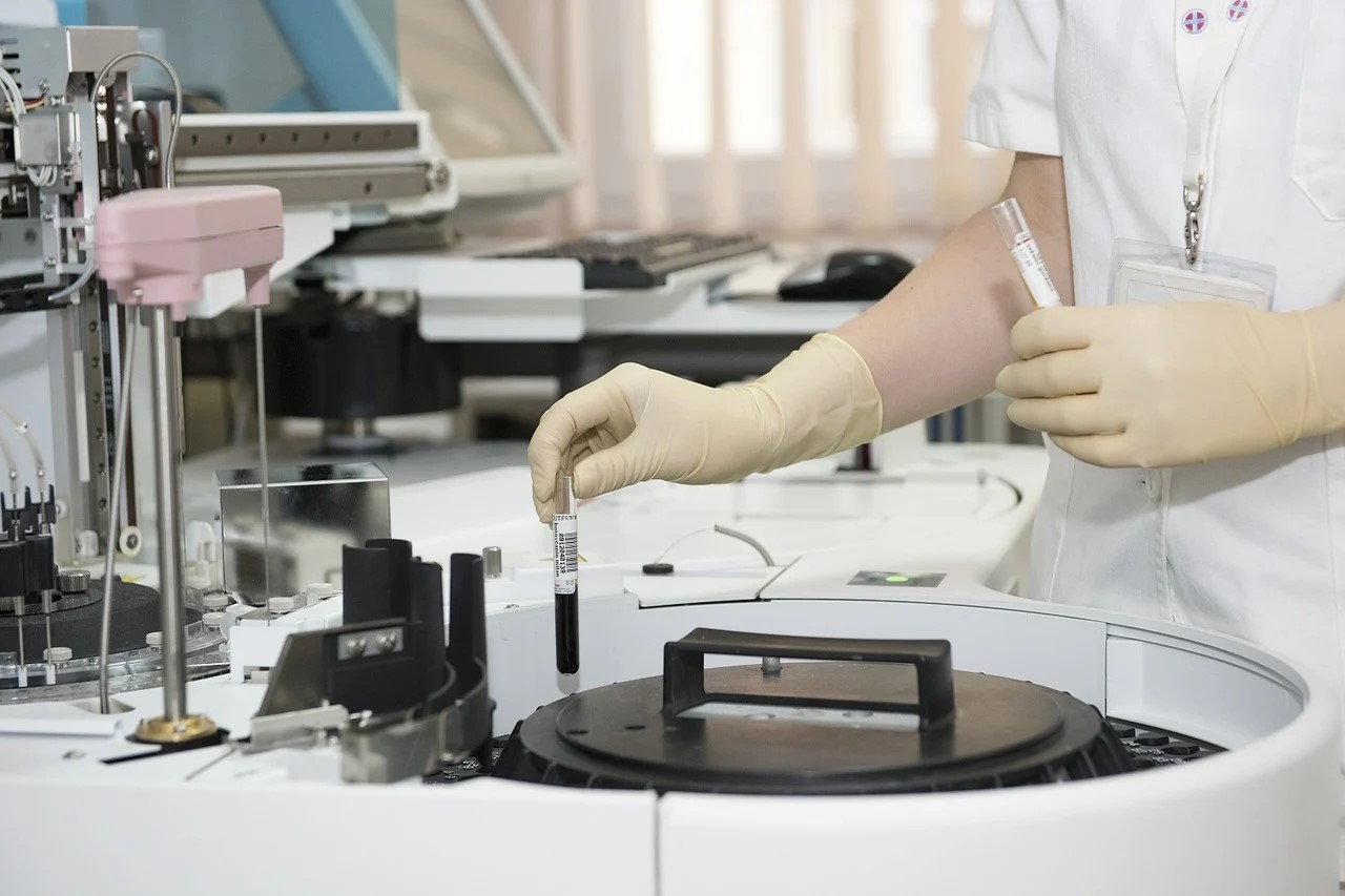 Pessoa com amostras de sangue introduzindo dentro de uma centrífuga