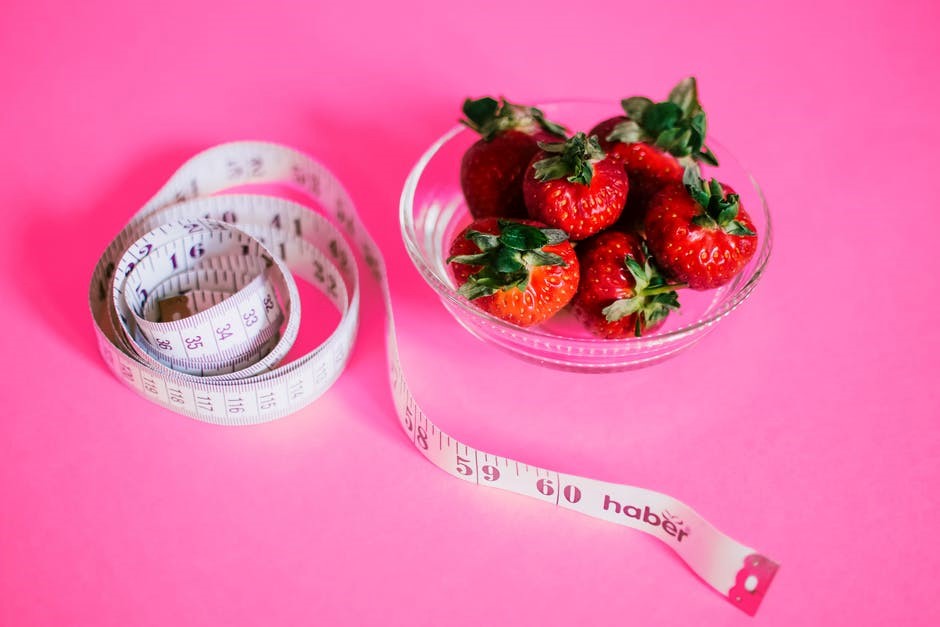 Nutrição e Dietética, Uma foto de fundo roda, com uma fita metrica e um pote de vidro com morangos