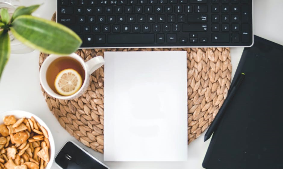 Nutrição e Dietética, Um notebook sobre a mesa com uma xícara de café, uma folha em branco, celular e caneta para anotações